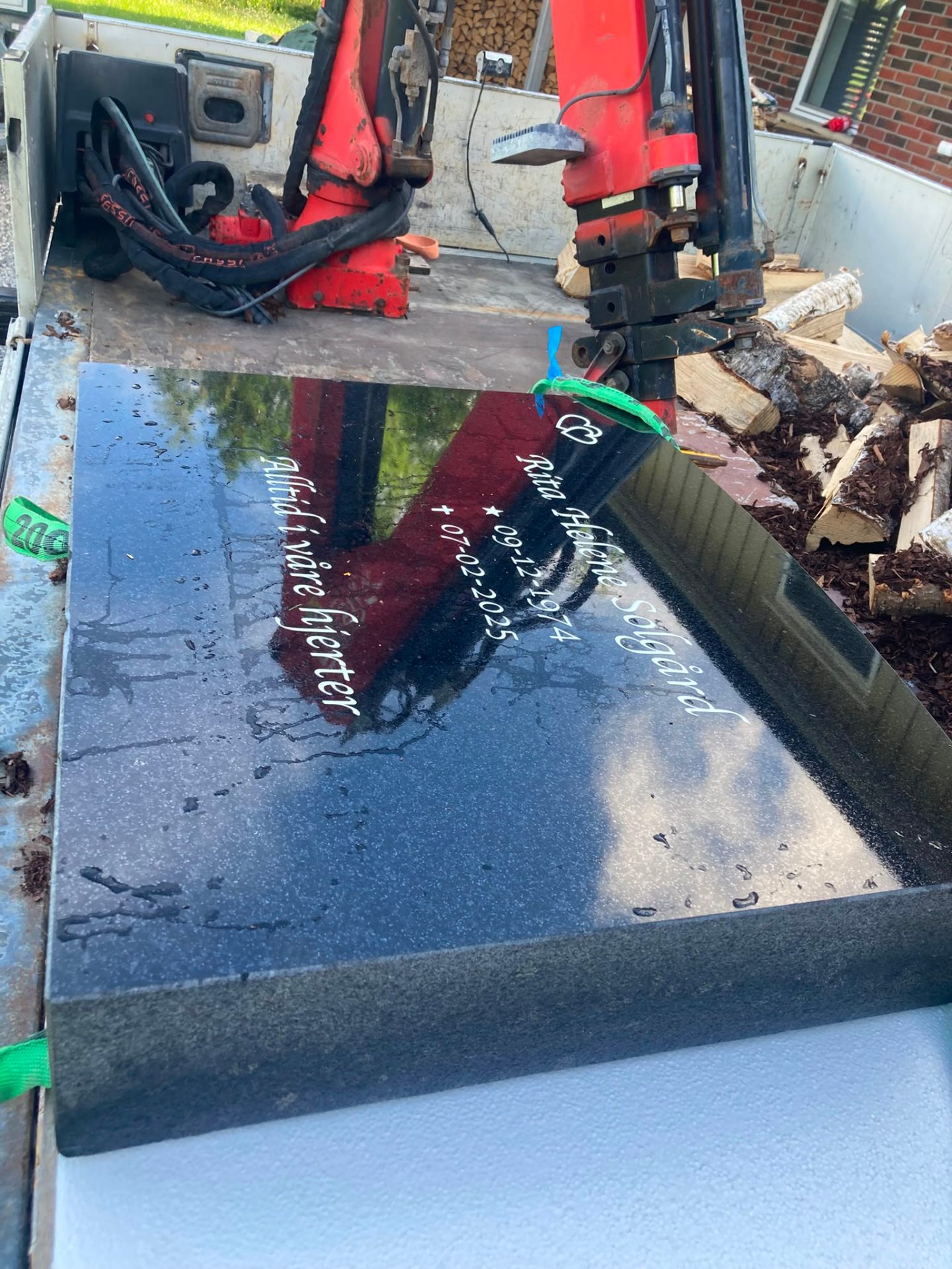 Steinen våt etter lakkering, med ny inskripsjon i skrift.